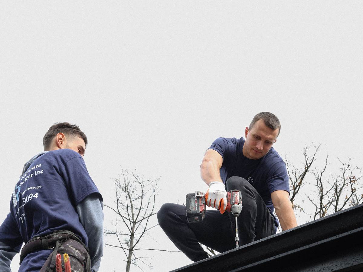 Drill being used on roof edge for gutter installation